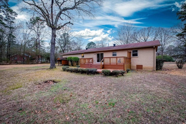 back of house with a deck and a lawn