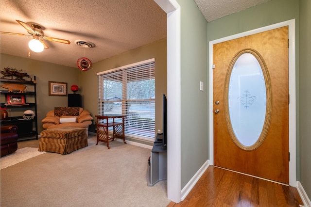 entryway with ceiling fan, hardwood / wood-style floors, and a textured ceiling