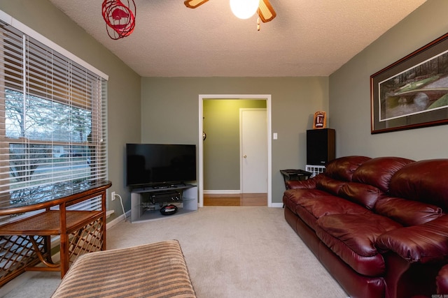 living room with light colored carpet, a textured ceiling, and ceiling fan