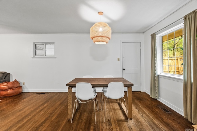 dining space featuring crown molding and dark wood-type flooring