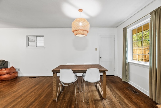 dining space featuring ornamental molding and dark hardwood / wood-style floors