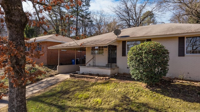 ranch-style home featuring a front lawn and a carport