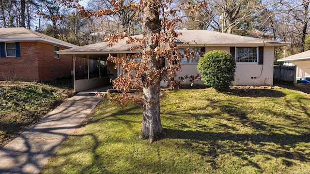 view of front facade with a sunroom and a front yard