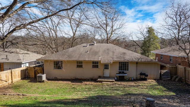 back of house featuring cooling unit and a lawn