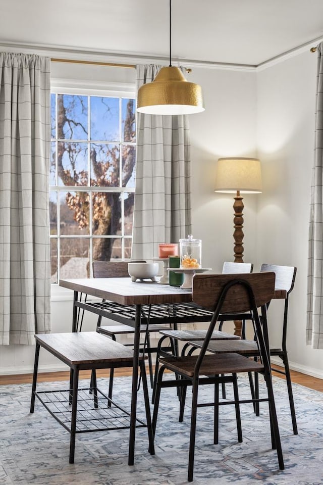 dining area with hardwood / wood-style floors and crown molding