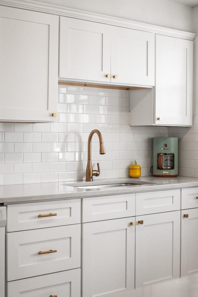 kitchen with white cabinetry, sink, and decorative backsplash