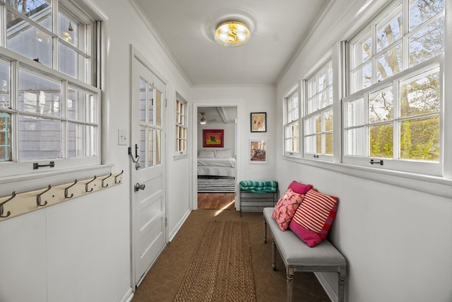 mudroom featuring crown molding and dark tile patterned floors