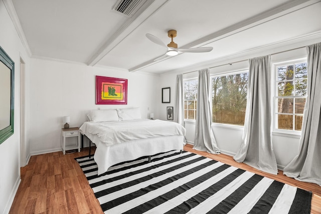 bedroom featuring hardwood / wood-style flooring, ceiling fan, crown molding, and beamed ceiling