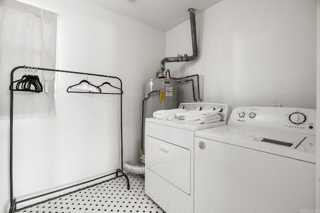 washroom with a baseboard heating unit, water heater, and washing machine and clothes dryer