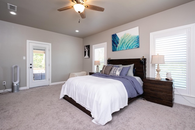 bedroom with multiple windows, access to outside, light colored carpet, and ceiling fan