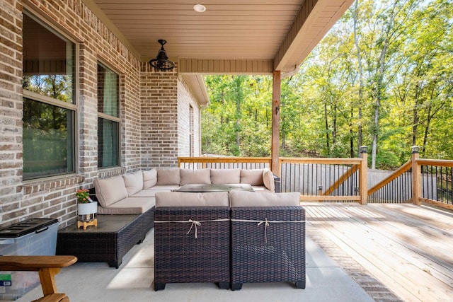 wooden deck with an outdoor hangout area and ceiling fan