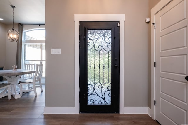 entrance foyer featuring dark hardwood / wood-style flooring and a notable chandelier