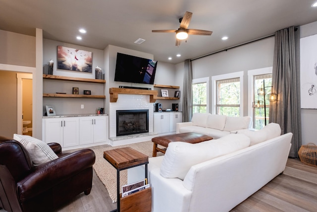 living room featuring ceiling fan and light hardwood / wood-style flooring