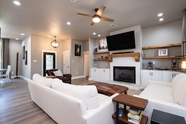 living room with light hardwood / wood-style flooring and ceiling fan