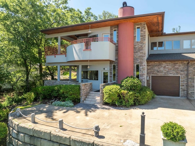 rear view of property featuring a garage and a balcony