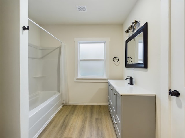 bathroom featuring wood-type flooring, vanity, and shower / bath combo