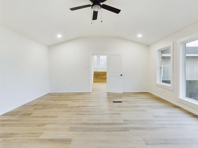 empty room featuring vaulted ceiling, ceiling fan, and light wood-type flooring