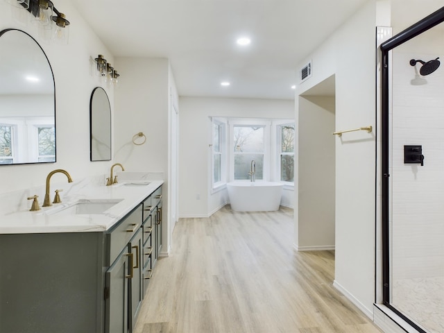 bathroom with vanity, hardwood / wood-style floors, and plus walk in shower