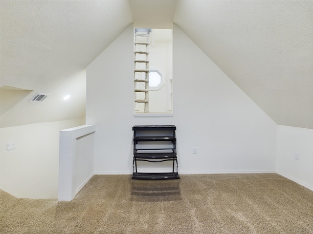 bonus room featuring lofted ceiling, carpet floors, and a textured ceiling