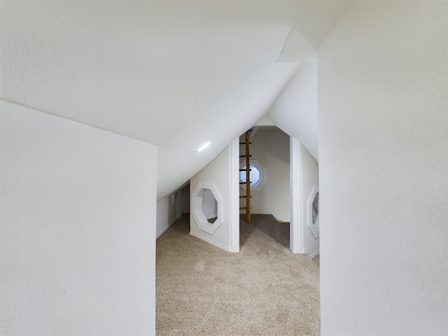 unfurnished bedroom featuring light colored carpet and lofted ceiling