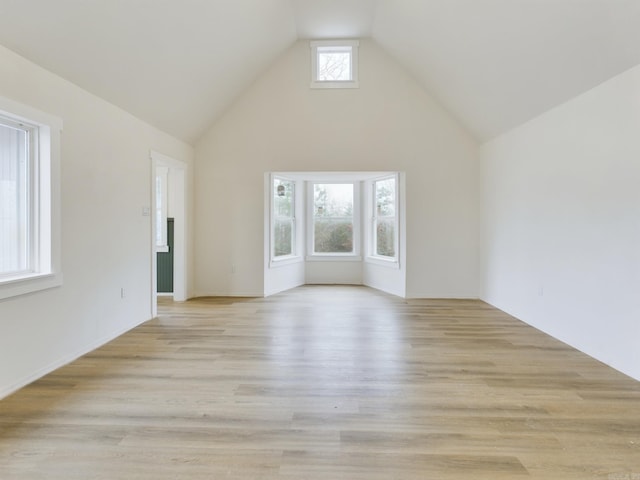 unfurnished living room featuring high vaulted ceiling and light hardwood / wood-style floors