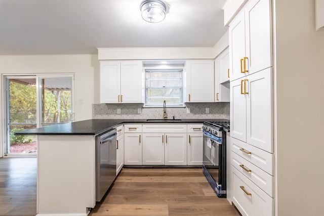 kitchen with white cabinetry, sink, stainless steel dishwasher, kitchen peninsula, and gas range oven