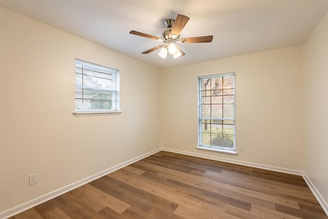 unfurnished room with ceiling fan, wood-type flooring, and a wealth of natural light