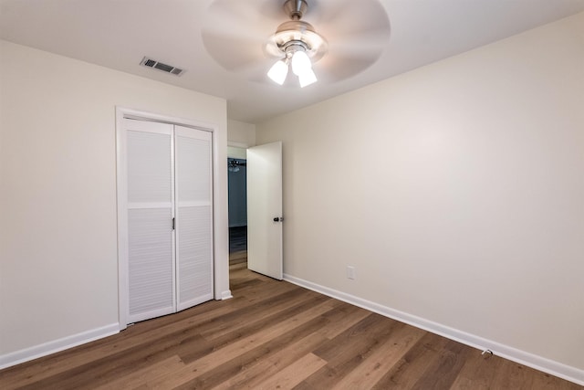 unfurnished bedroom featuring hardwood / wood-style flooring, ceiling fan, and a closet