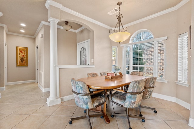 tiled dining space featuring decorative columns and ornamental molding