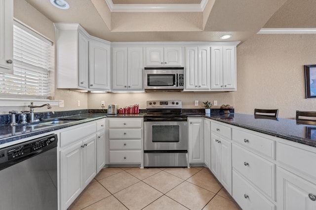 kitchen with crown molding, white cabinets, and appliances with stainless steel finishes