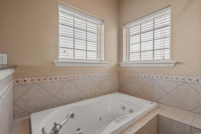 bathroom with plenty of natural light and tiled bath