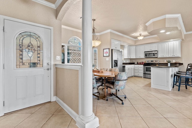 entryway featuring crown molding, a textured ceiling, and light tile patterned floors