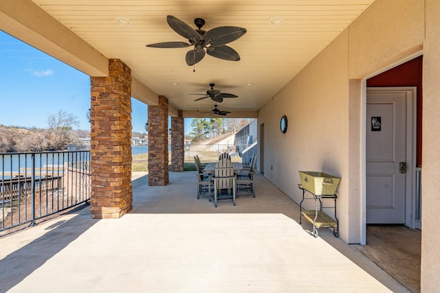 view of patio / terrace with ceiling fan and a water view