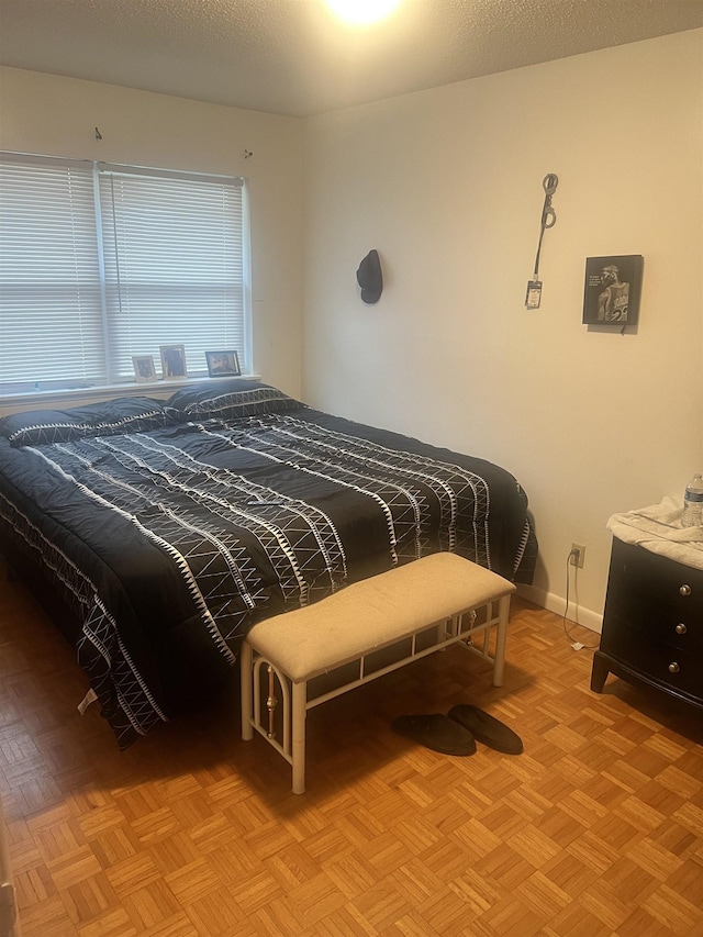 bedroom featuring a textured ceiling and light parquet flooring