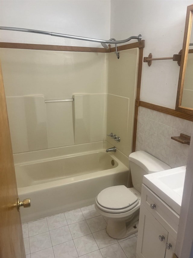 full bathroom featuring tile patterned floors, toilet, bathing tub / shower combination, tile walls, and vanity