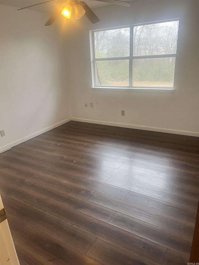 unfurnished room featuring dark wood-type flooring and ceiling fan