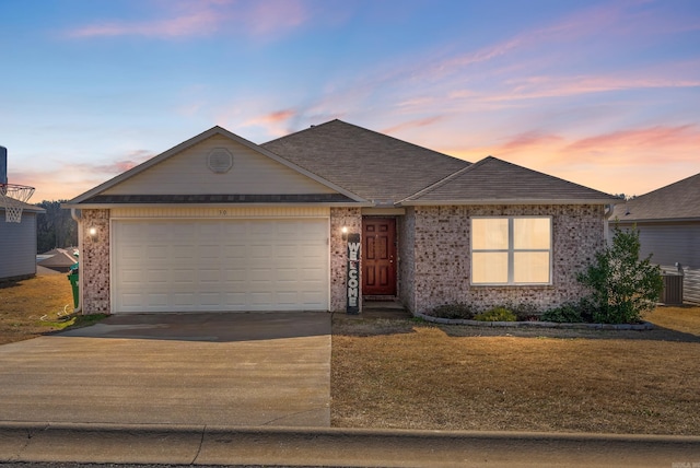 ranch-style home with central AC unit and a garage