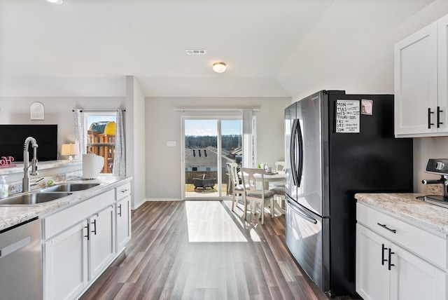 kitchen with stainless steel appliances, light stone countertops, sink, and white cabinets