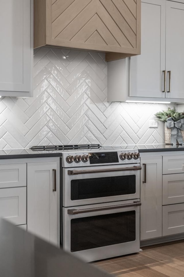 kitchen featuring backsplash, dark hardwood / wood-style floors, and range with two ovens