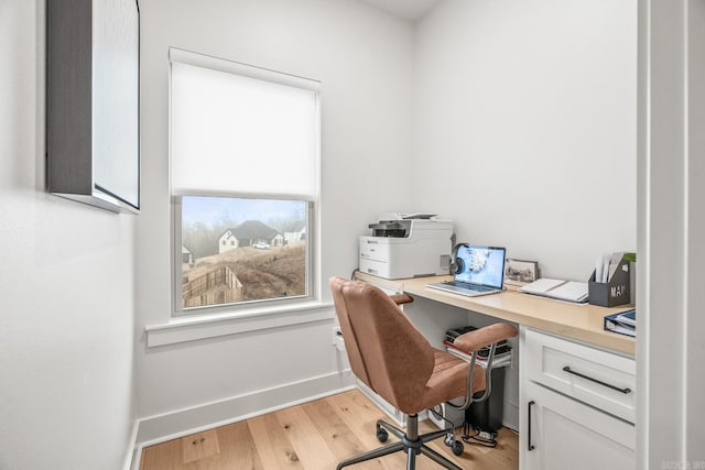 office area with built in desk and light hardwood / wood-style flooring