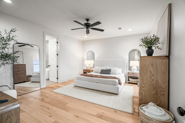 bedroom with ensuite bathroom, ceiling fan, and light hardwood / wood-style flooring