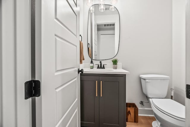 bathroom with vanity, wood-type flooring, and toilet