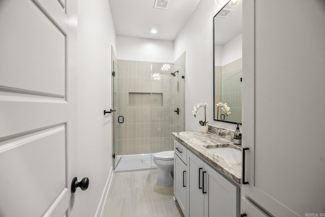 bathroom featuring walk in shower, vanity, and toilet