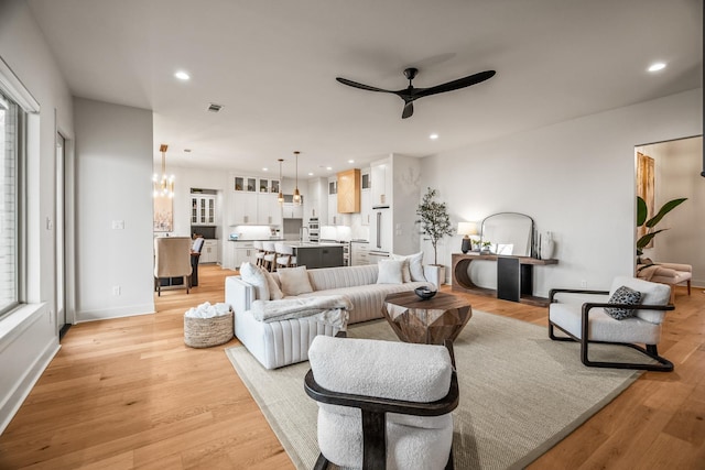 living room featuring light hardwood / wood-style flooring and ceiling fan