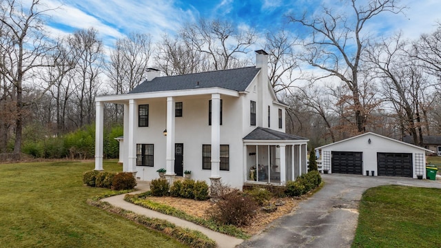 view of front of home featuring a garage, an outdoor structure, and a front yard