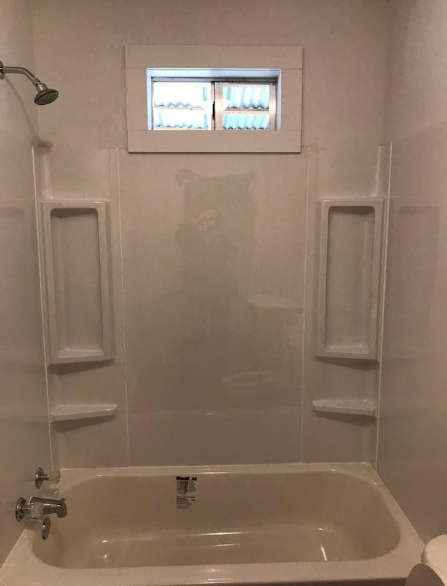 bathroom featuring shower / bathing tub combination and toilet