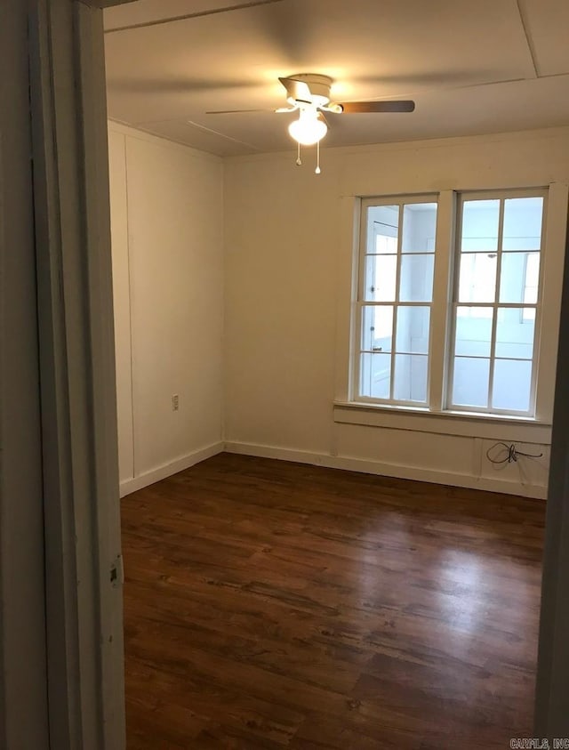 empty room with dark wood-type flooring and ceiling fan