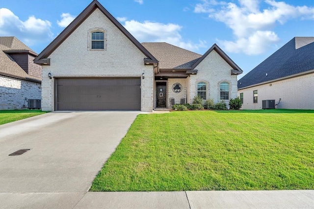 french country style house featuring a garage, cooling unit, and a front lawn