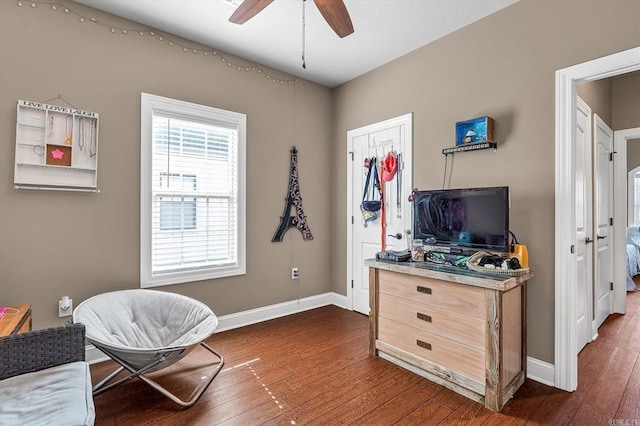 sitting room with dark wood-type flooring and ceiling fan