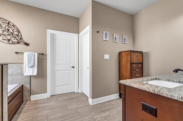 bathroom with vanity and a washtub